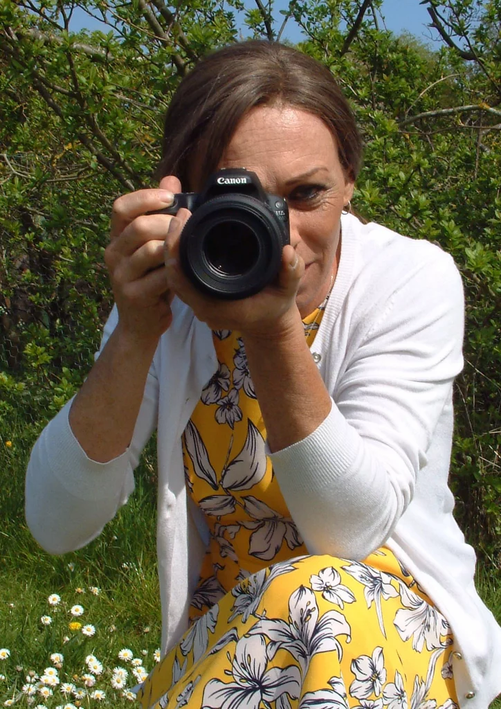 Sarah Perkins, a wildlife photographer, is taking your picture with a Canon camera.